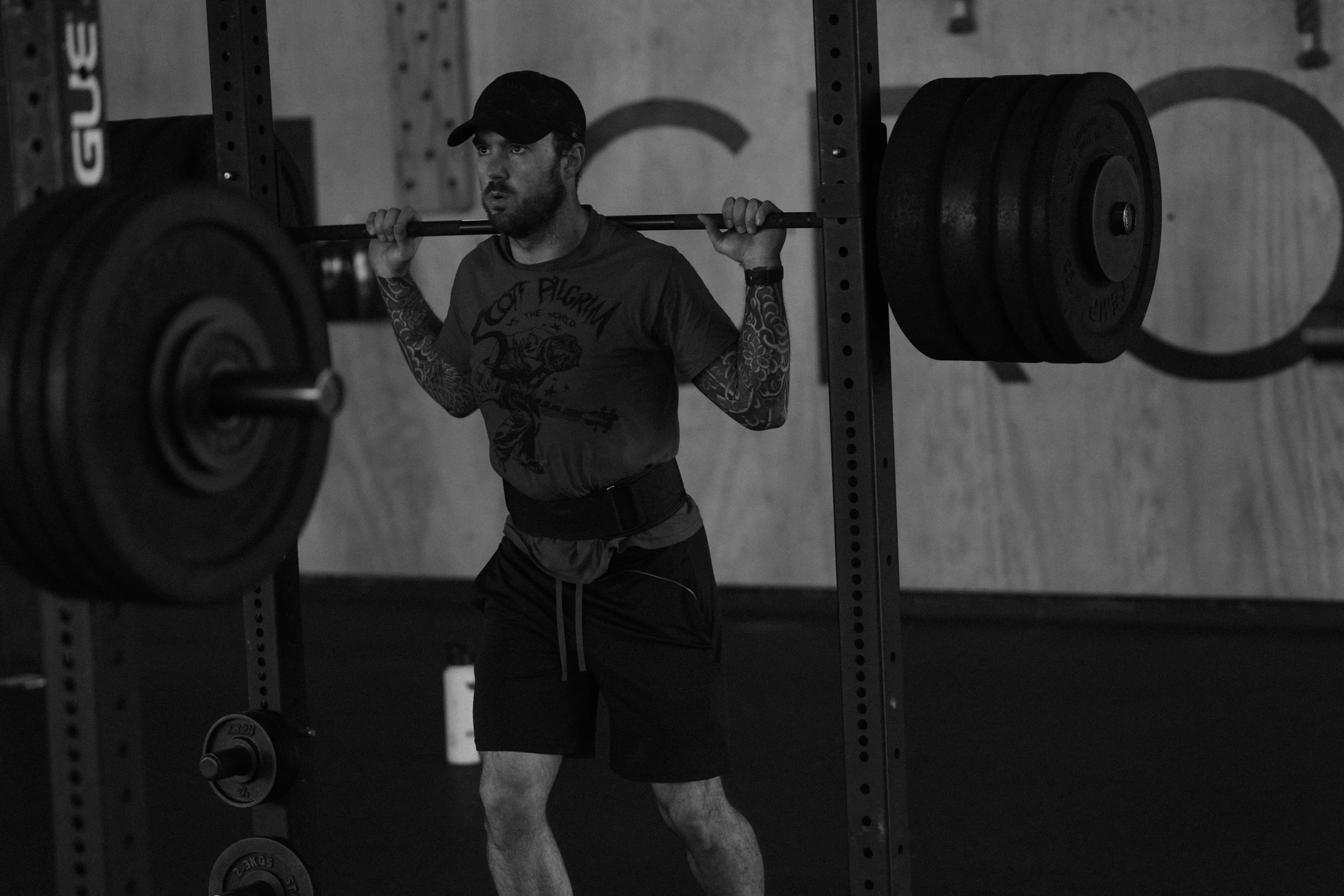 Member back-squatting with focused coaching attention